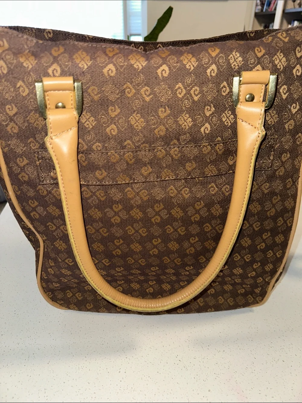 This is a brown Pierre Cardin monogram logo tote bag with beige leather handles.